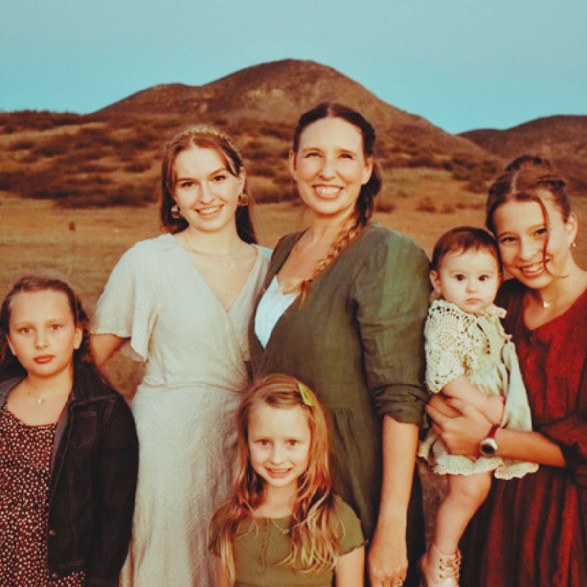 mother and daughters in dresses outdoors